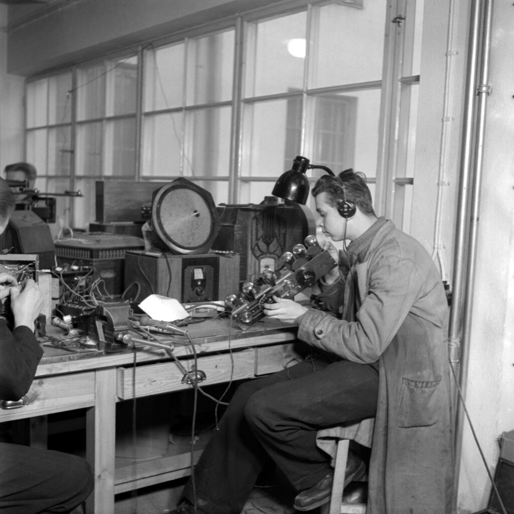 a man repairing an old telephone in 1930s